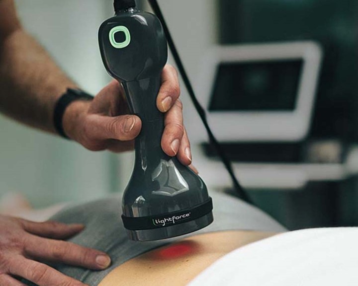 closeup of a provider using a laser tool to treat a patients low back